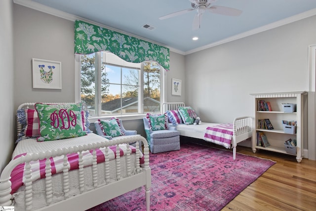 bedroom with ceiling fan, hardwood / wood-style floors, and crown molding