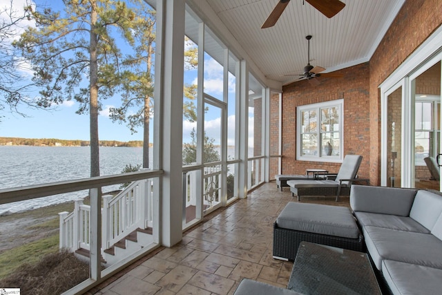 sunroom featuring a water view and ceiling fan