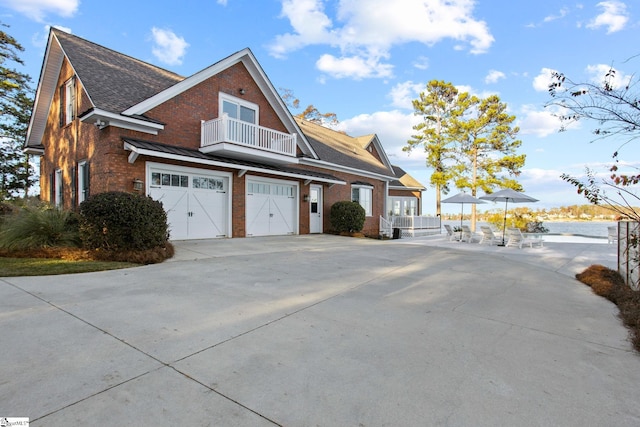 view of side of home featuring a garage and a balcony