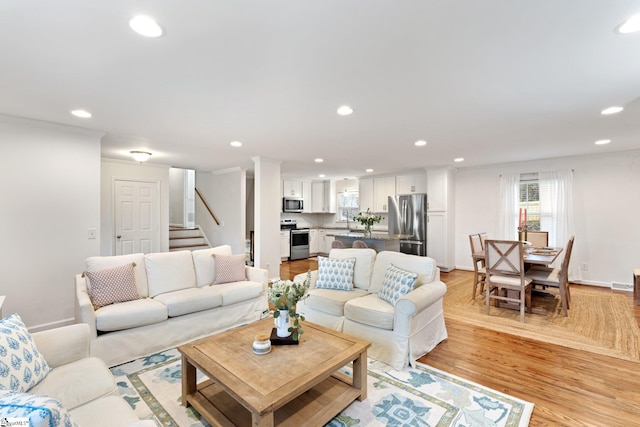 living room featuring sink and light hardwood / wood-style floors