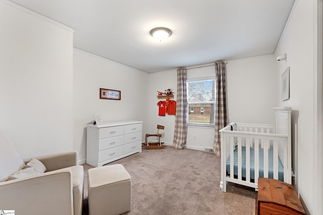 carpeted bedroom with crown molding and a nursery area