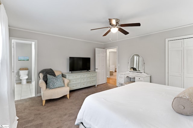 carpeted bedroom with crown molding, a closet, ensuite bath, and ceiling fan