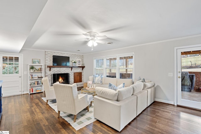 living room with ceiling fan, dark hardwood / wood-style flooring, ornamental molding, and a fireplace