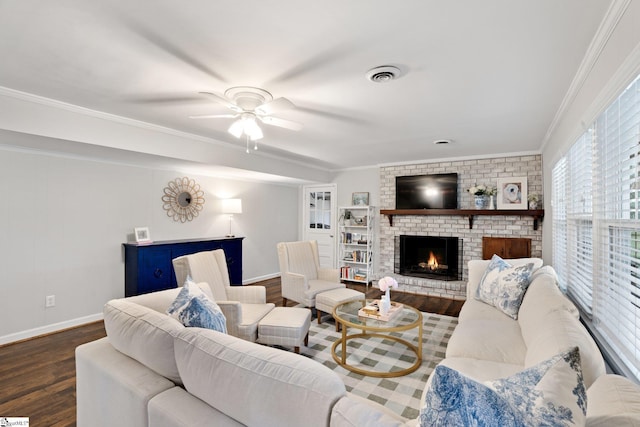 living room featuring crown molding, dark hardwood / wood-style floors, a fireplace, and ceiling fan