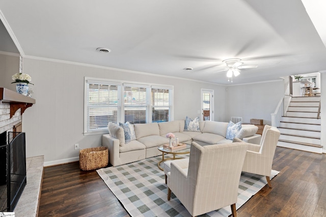 living room featuring dark wood-type flooring, a brick fireplace, and ornamental molding