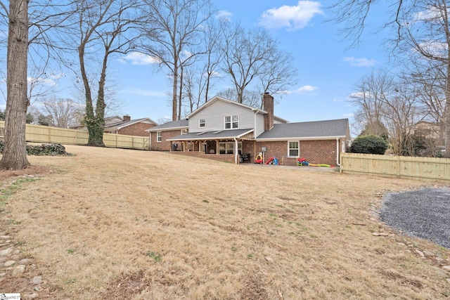 rear view of house featuring a patio area and a lawn