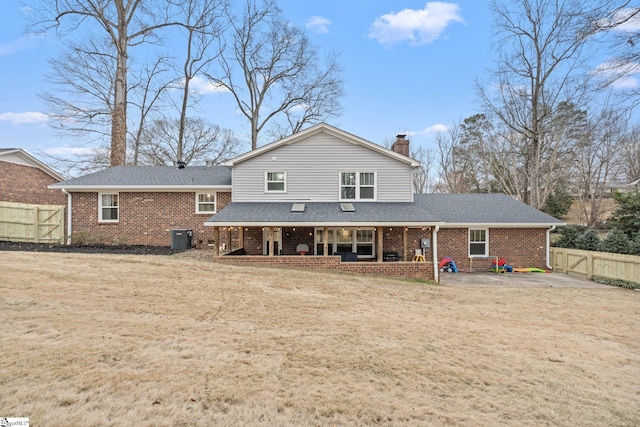 rear view of property featuring cooling unit, a yard, and a patio