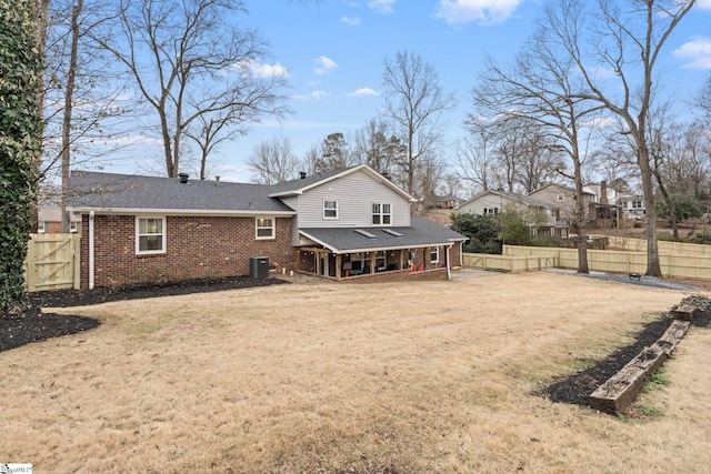 back of house featuring a lawn and cooling unit