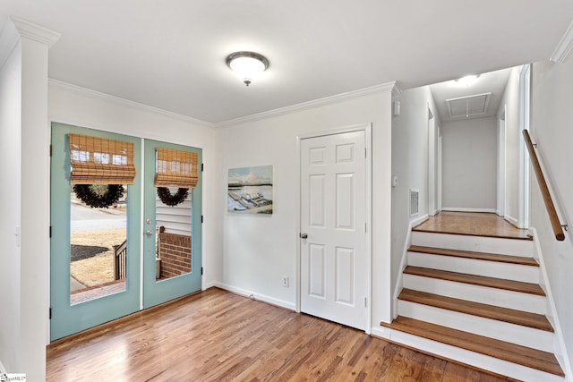 foyer entrance featuring hardwood / wood-style flooring, french doors, and crown molding