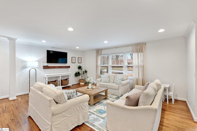 living room featuring a fireplace, ornamental molding, and light wood-type flooring