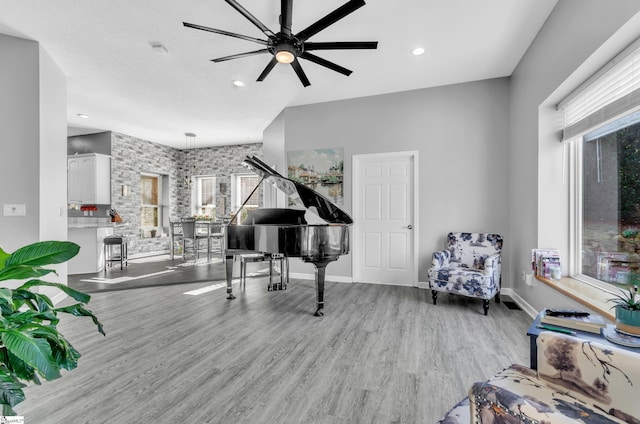 sitting room featuring light wood-type flooring, ceiling fan, and a healthy amount of sunlight