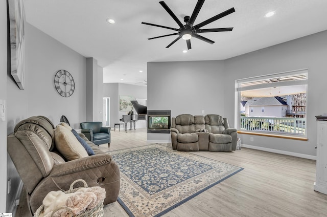 living room with light hardwood / wood-style floors, a wealth of natural light, and ceiling fan