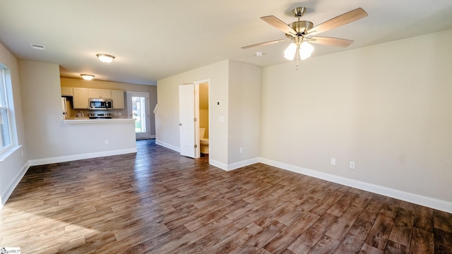 unfurnished living room featuring ceiling fan and hardwood / wood-style floors