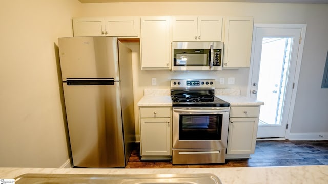 kitchen featuring hardwood / wood-style flooring, white cabinetry, and appliances with stainless steel finishes