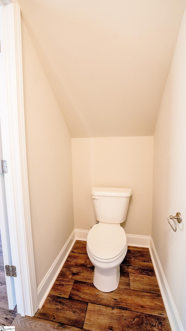 bathroom featuring toilet, wood-type flooring, and lofted ceiling