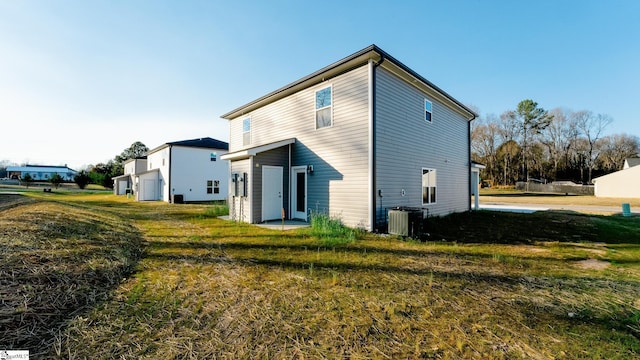 rear view of house with a lawn and central air condition unit