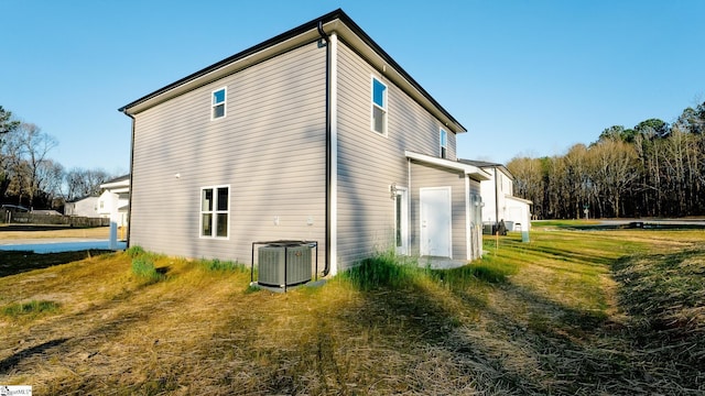 view of property exterior with a lawn and central air condition unit