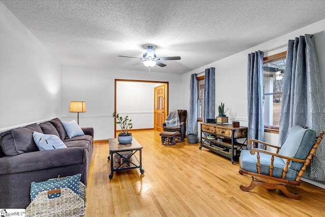 living room with hardwood / wood-style floors, a textured ceiling, and ceiling fan