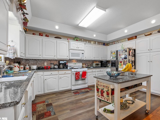 kitchen with white appliances, tasteful backsplash, white cabinetry, sink, and dark hardwood / wood-style flooring