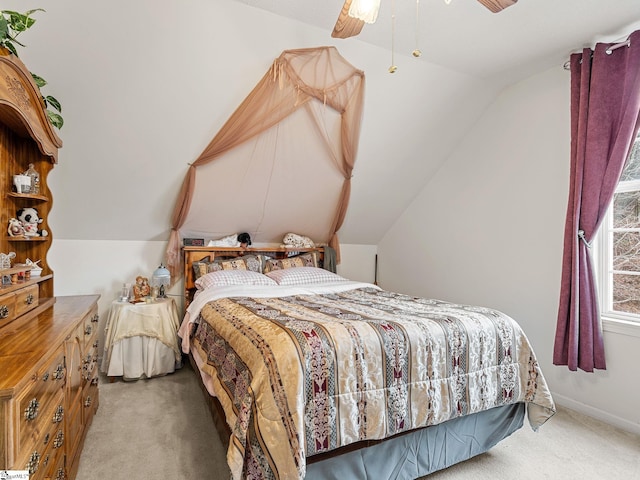 carpeted bedroom with ceiling fan and vaulted ceiling