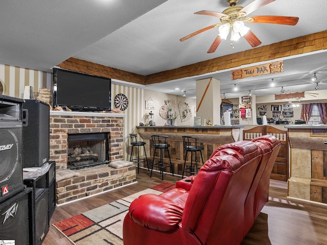 living room featuring hardwood / wood-style flooring, bar area, a textured ceiling, and a fireplace