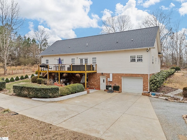 rear view of house featuring a deck and a garage