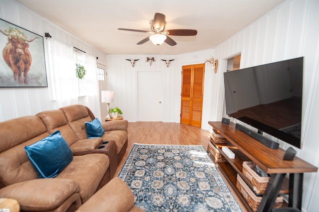 living room featuring wood-type flooring and ceiling fan