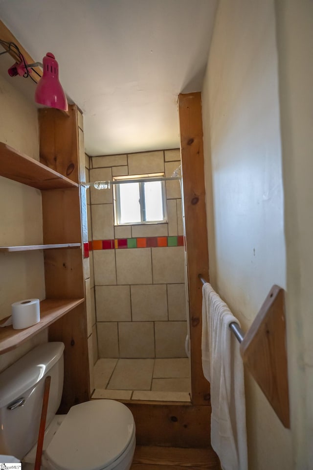 bathroom with toilet and tiled shower