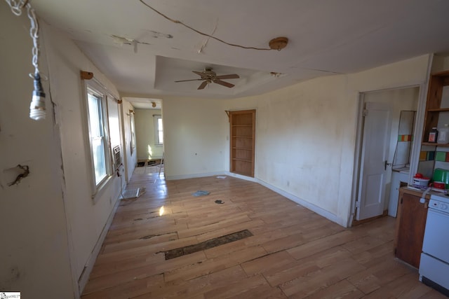 interior space featuring ceiling fan, light hardwood / wood-style flooring, and a raised ceiling