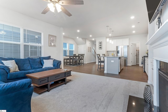 living room featuring ceiling fan, wood-type flooring, and sink