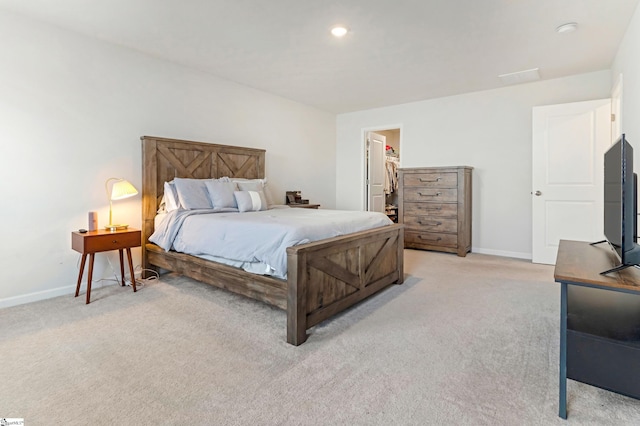 carpeted bedroom featuring a spacious closet and a closet