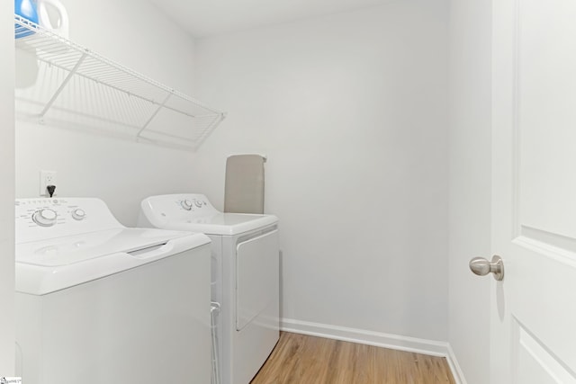 clothes washing area with wood-type flooring and washing machine and clothes dryer