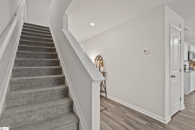 stairs featuring wood-type flooring