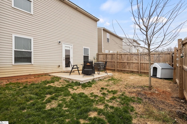 rear view of property featuring a storage shed and a patio