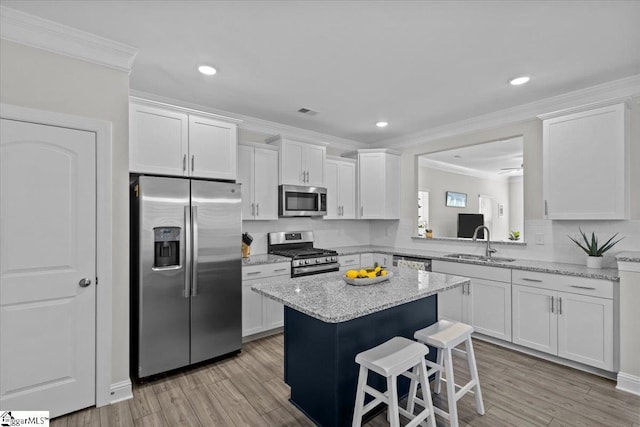 kitchen with stainless steel appliances, white cabinetry, and sink