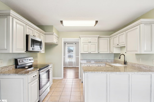 kitchen with light tile patterned flooring, white cabinetry, sink, kitchen peninsula, and stainless steel appliances