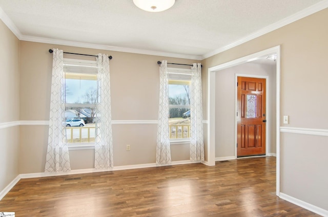 entryway with ornamental molding, plenty of natural light, dark hardwood / wood-style floors, and a textured ceiling