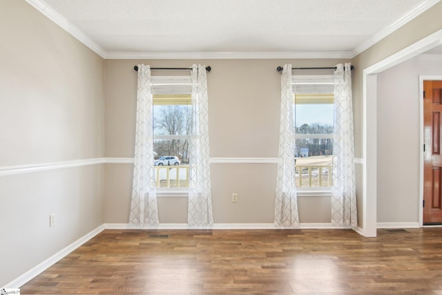 spare room featuring hardwood / wood-style flooring, ornamental molding, and a textured ceiling