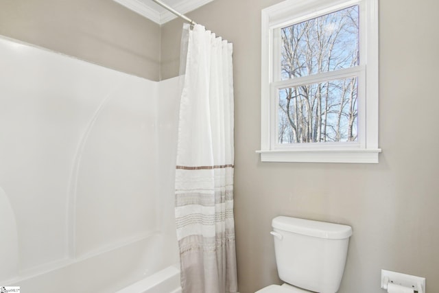 bathroom with shower / bathtub combination with curtain, crown molding, and toilet