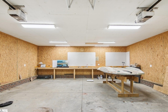 interior space featuring concrete floors, a workshop area, and wood walls