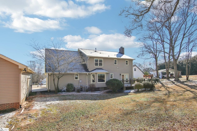 rear view of house with a yard and central AC