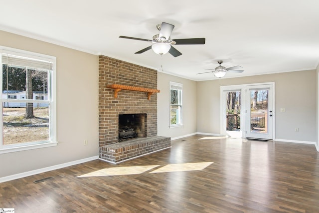 unfurnished living room featuring a brick fireplace, dark hardwood / wood-style floors, and ceiling fan