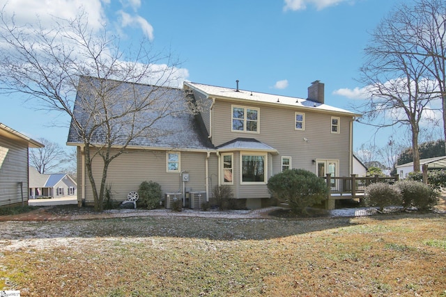 back of property featuring a wooden deck, central AC, and a lawn