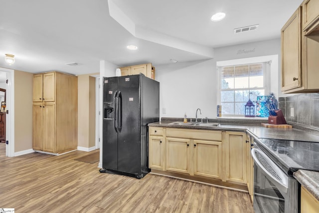 kitchen featuring stainless steel electric range oven, light brown cabinetry, sink, black refrigerator with ice dispenser, and light hardwood / wood-style flooring