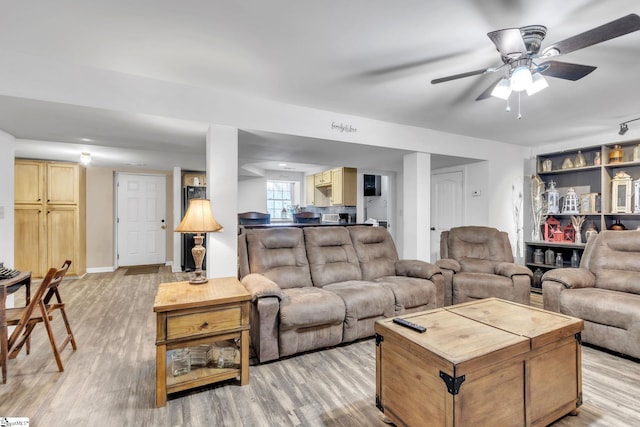 living room featuring ceiling fan and light hardwood / wood-style flooring