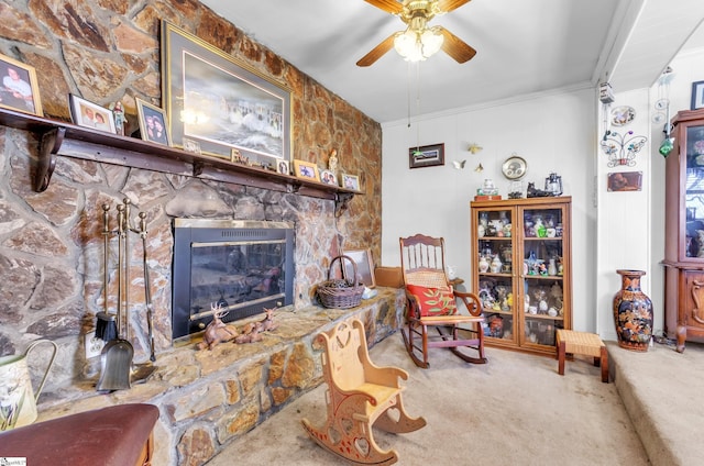 carpeted living room with crown molding, a fireplace, and ceiling fan