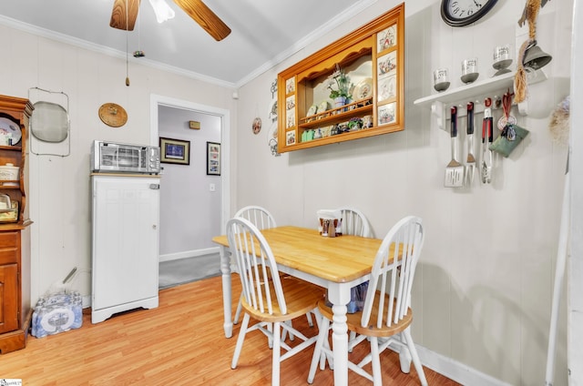 dining room featuring ornamental molding, ceiling fan, and light wood-type flooring