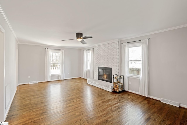 unfurnished living room featuring a fireplace, ornamental molding, and wood-type flooring