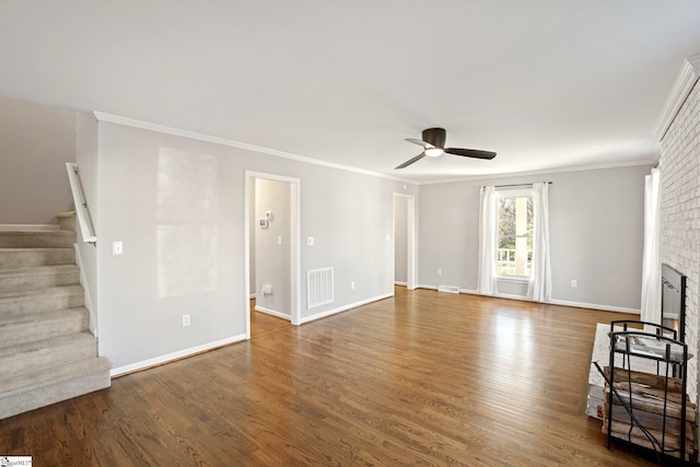 unfurnished living room featuring crown molding, a brick fireplace, ceiling fan, and dark hardwood / wood-style flooring