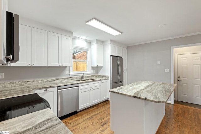 kitchen with a kitchen island, dark hardwood / wood-style floors, white cabinetry, light stone counters, and stainless steel appliances